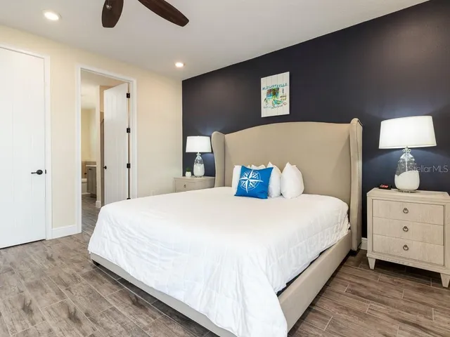 a bedroom with a bed and a lamp on dresser