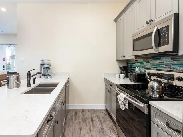 a kitchen with stainless steel appliances a dining table and chairs