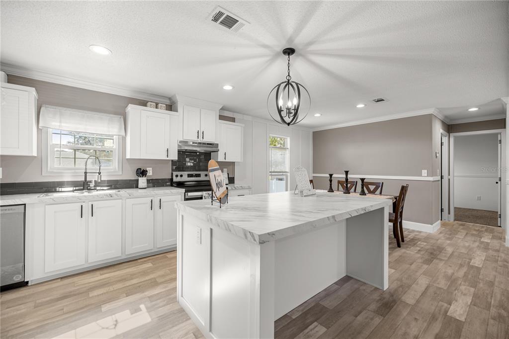 1550 Northeast 162nd Street Citra, FL 32113 - Photo 6 of 33 a kitchen with stainless steel appliances granite countertop a sink a stove a refrigerator cabinets and a dining table