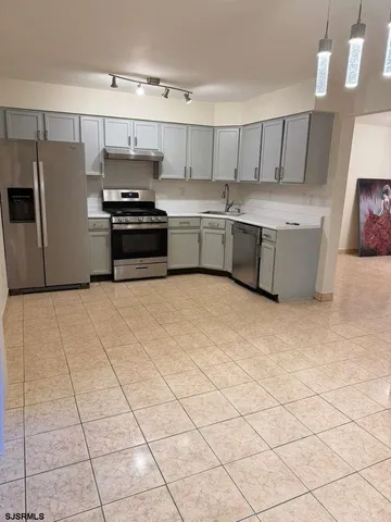 a kitchen with stainless steel appliances a stove a sink and a refrigerator