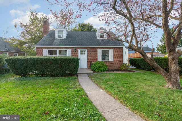 a front view of a house with a yard and trees
