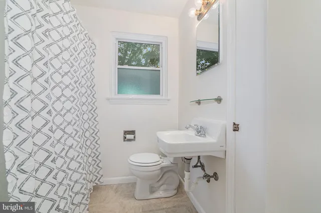 a bathroom with a toilet sink and mirror