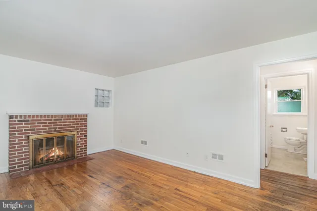 a view of empty room with wooden floor and fireplace