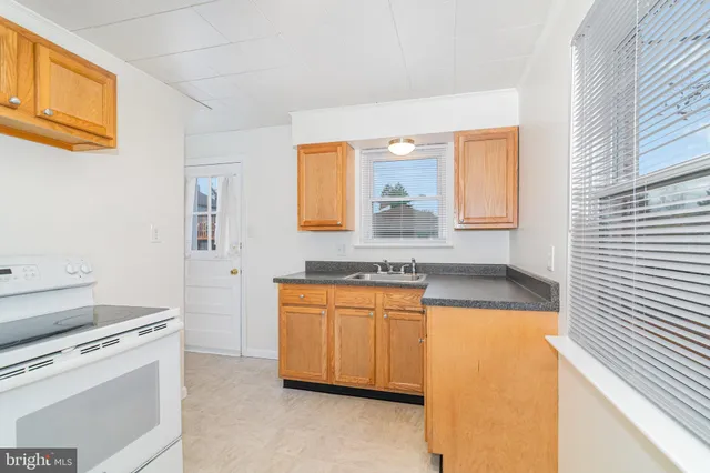 a kitchen with stainless steel appliances granite countertop a sink and a stove with white countertops