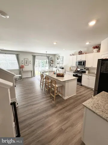 a living room with couches painting on the wall and a large window