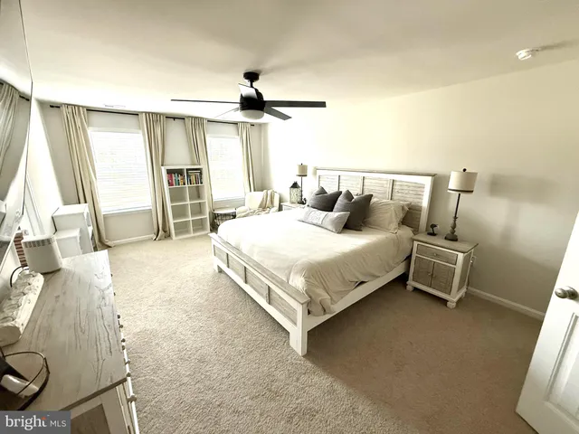a living room with furniture and a ceiling fan