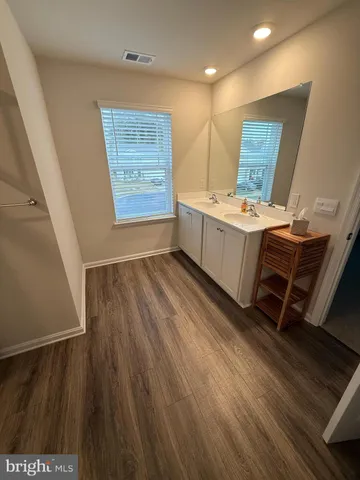 an empty room with wooden floor and entrance