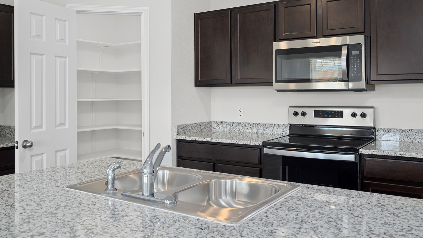 1407 Victory Rnch Trail Killeen, TX 76549 - Photo 5 of 24 A well-appointed kitchen features a double-basin sink set into speckled granite countertops, complemented by rich cabinetry.