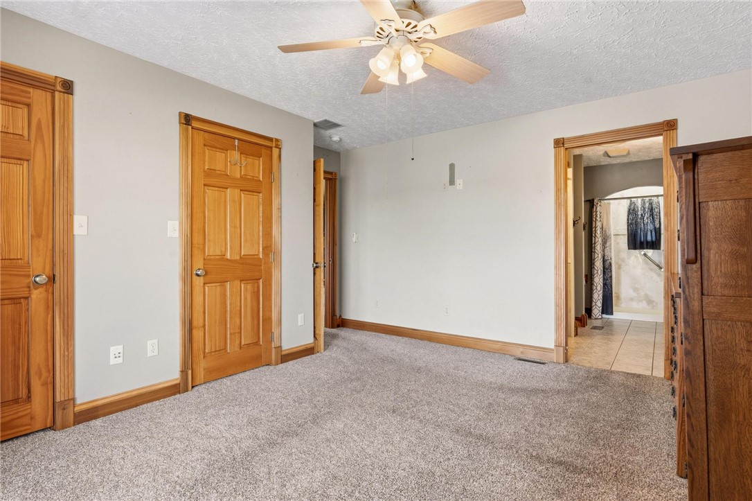 4971 Lackey Road Cedarville, OH 45314 - Photo 61 of 79 This cozy bedroom features warm wooden doors and a ceiling fan for comfort.