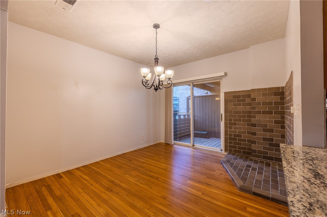 2472 Overlook Road Cleveland Heights, OH 44106 - Photo 8 of 30 Unfurnished dining area wood floors, hanging lights, and a textured ceiling