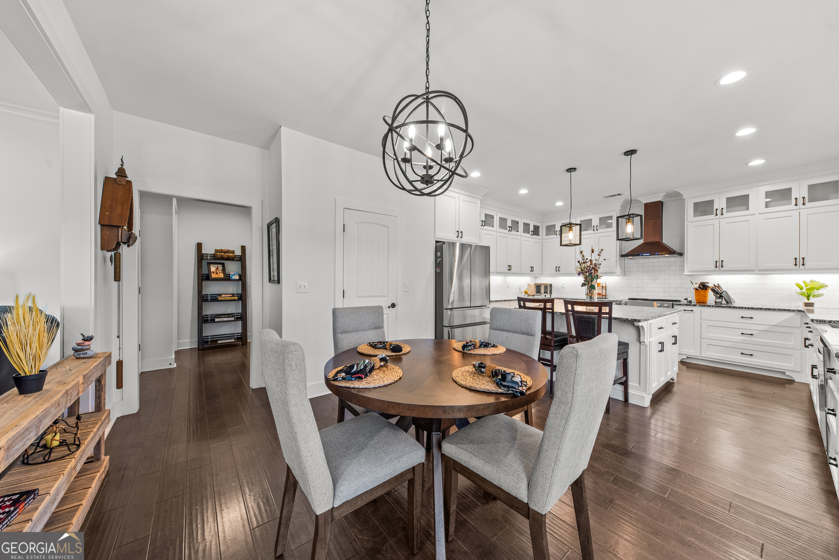 1100 West Magnolia Loop Madison, GA 30650 - Photo 12 of 40 a view of a dining room and livingroom with furniture wooden floor a chandelier