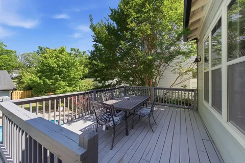 a balcony with wooden floor and outdoor seating