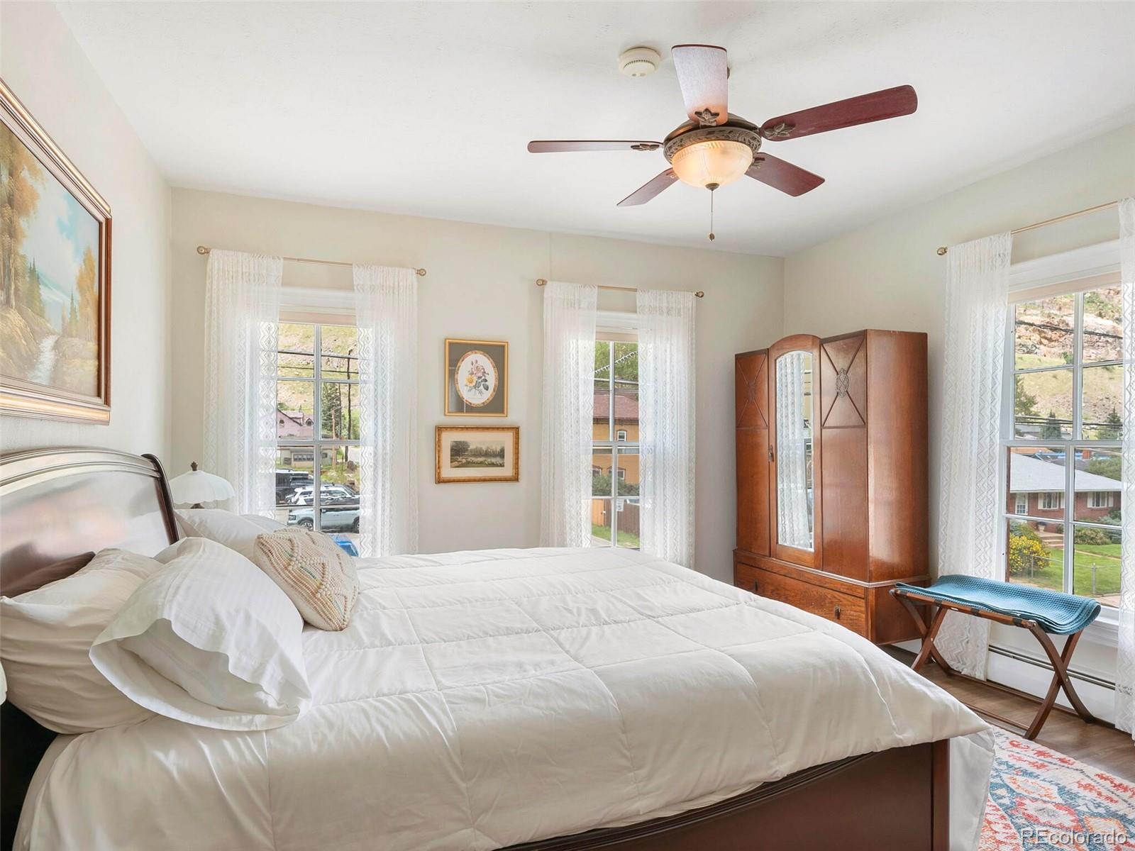 614 Rose Street Georgetown, CO 80444 - Photo 22 of 40 a bedroom with a large bed and a chandelier