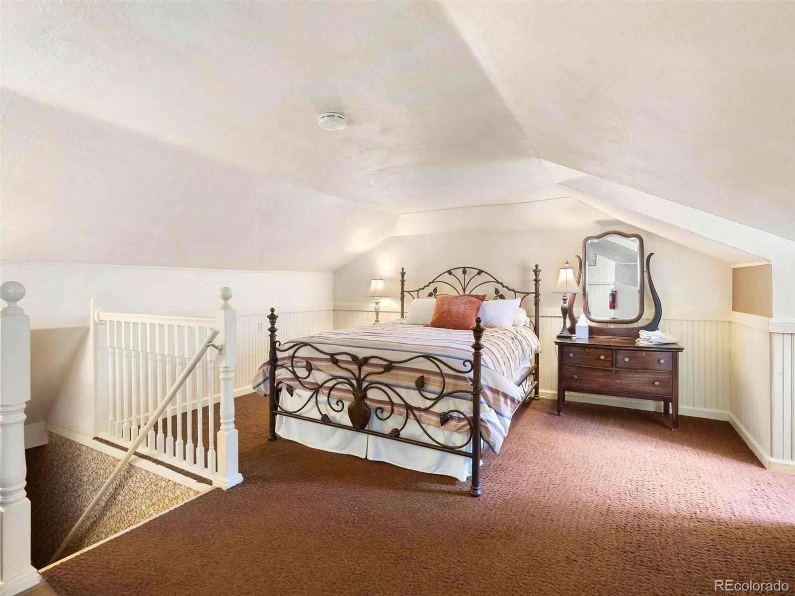 614 Rose Street Georgetown, CO 80444 - Photo 31 of 40 a bedroom with a bed and a night stand next to a window