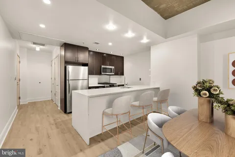 a living room with furniture a refrigerator and dining table