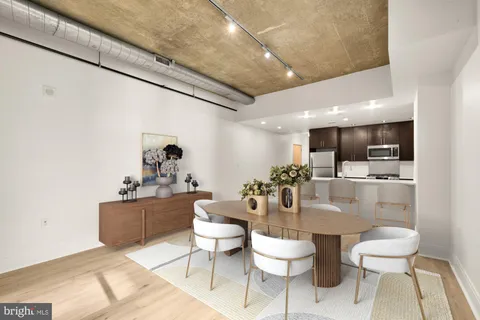 a dining room with wooden floor a chandelier a wooden table and chairs