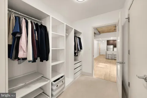 a view of walk in closet with clothes and shoes