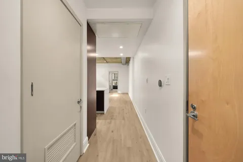 a view of a hallway with wooden floor and staircase