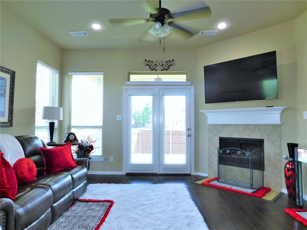 7712 Sweetgate Lane Denton, TX 76208 - Photo 15 of 40 a living room with furniture a flat screen tv and a fireplace
