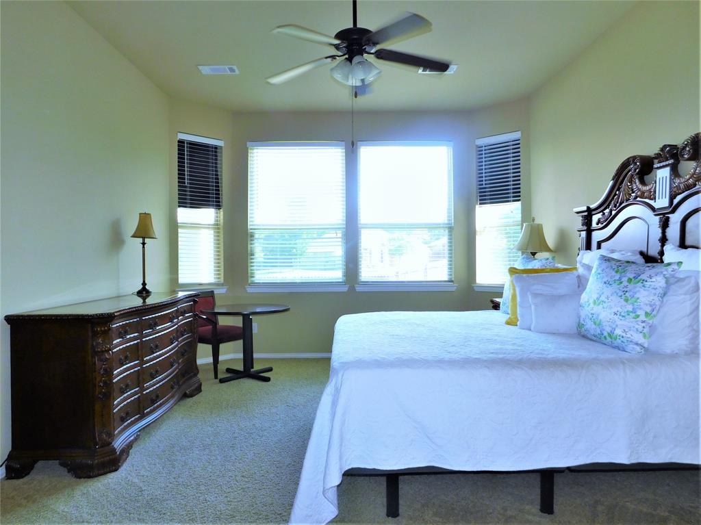 7712 Sweetgate Lane Denton, TX 76208 - Photo 16 of 40 a bedroom with a bed and a desk