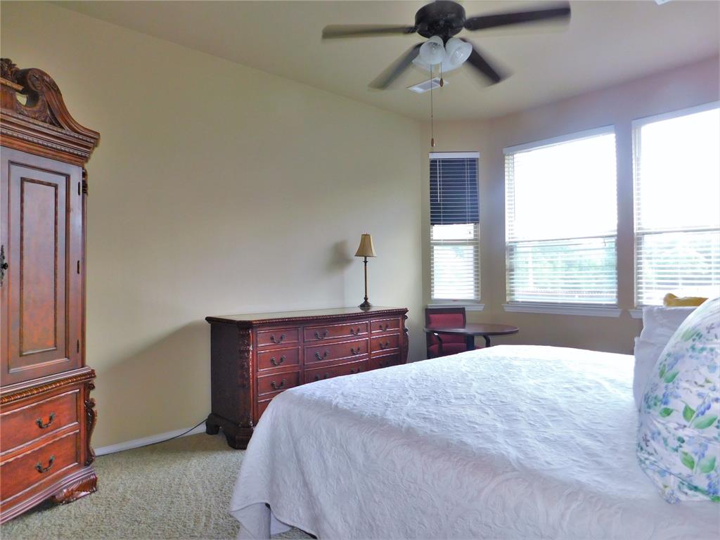 7712 Sweetgate Lane Denton, TX 76208 - Photo 18 of 40 a bedroom with a bed and a chandelier