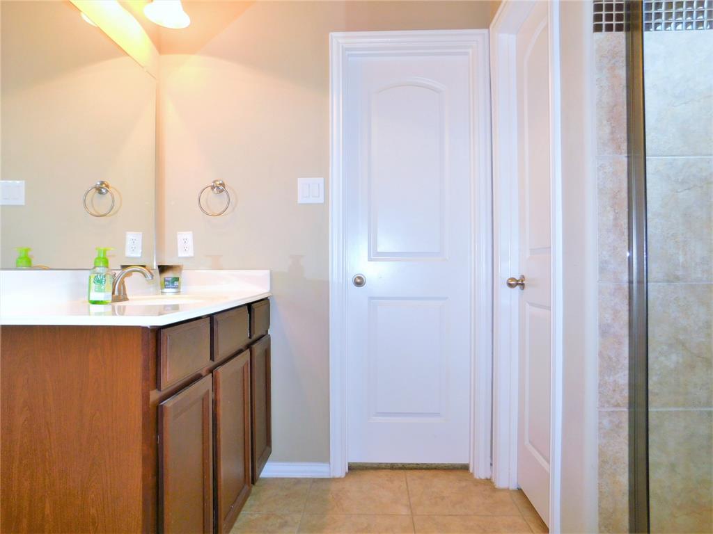 7712 Sweetgate Lane Denton, TX 76208 - Photo 19 of 40 a bathroom with a sink and a mirror