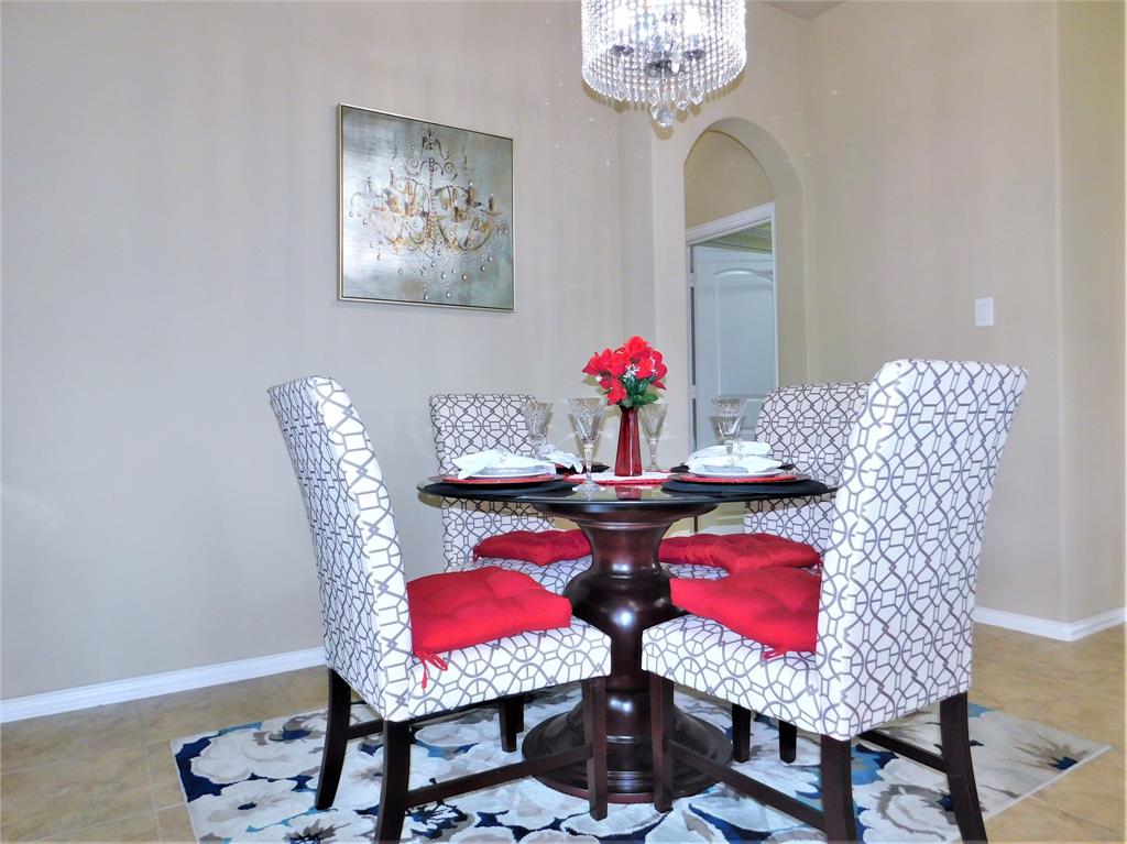 7712 Sweetgate Lane Denton, TX 76208 - Photo 27 of 40 a view of a dining room with furniture and chandelier