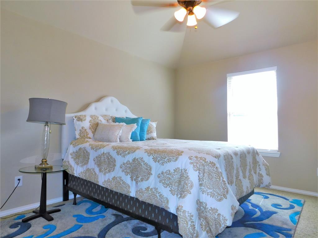 7712 Sweetgate Lane Denton, TX 76208 - Photo 30 of 40 a bedroom with a bed and a chandelier