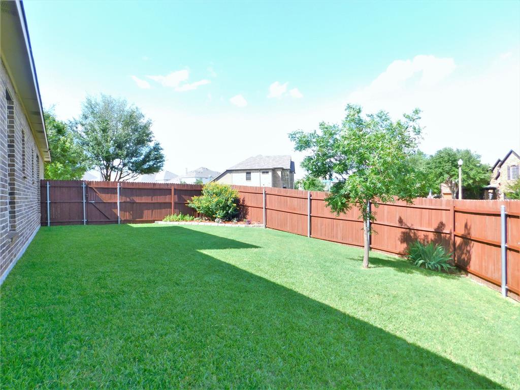 7712 Sweetgate Lane Denton, TX 76208 - Photo 34 of 40 a view of a backyard with a wooden fence
