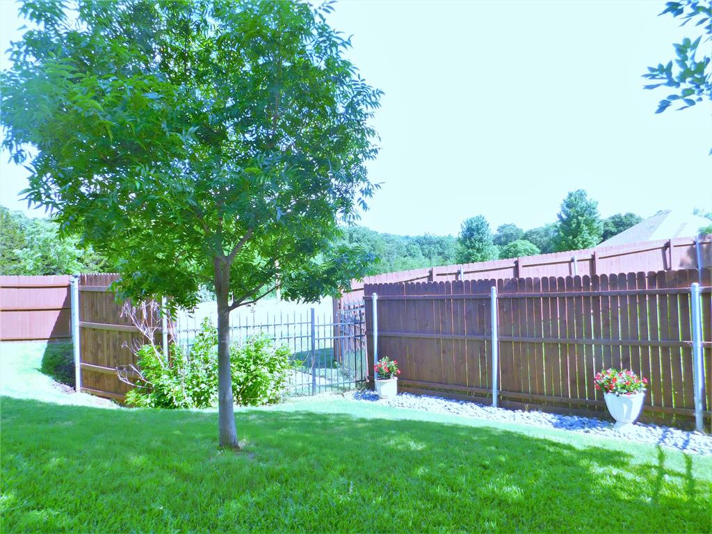 7712 Sweetgate Lane Denton, TX 76208 - Photo 36 of 40 a view of a backyard with a garden and deck