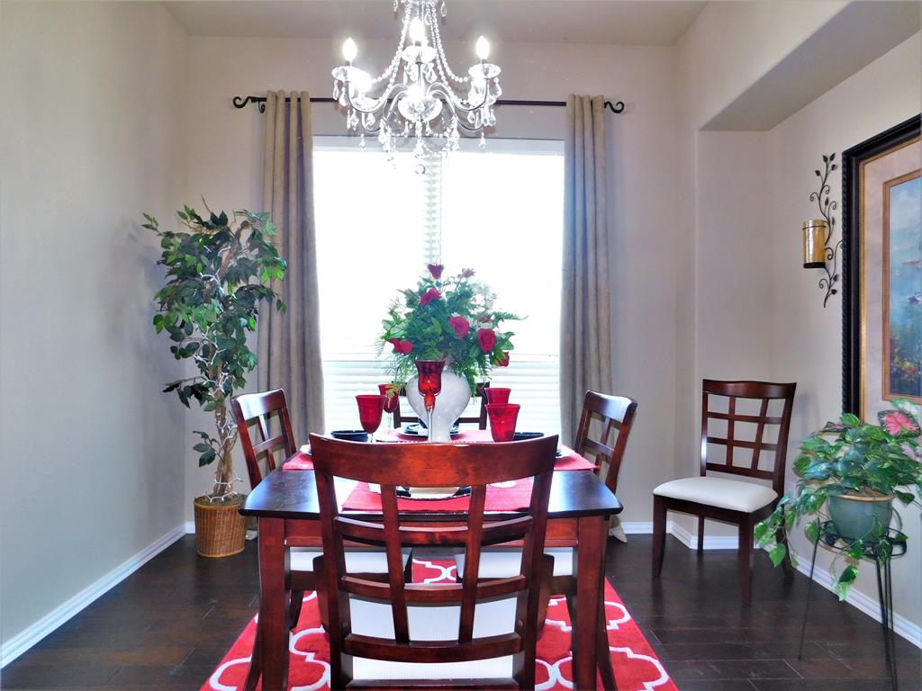 7712 Sweetgate Lane Denton, TX 76208 - Photo 5 of 40 a dining room with furniture potted plants and wooden floor