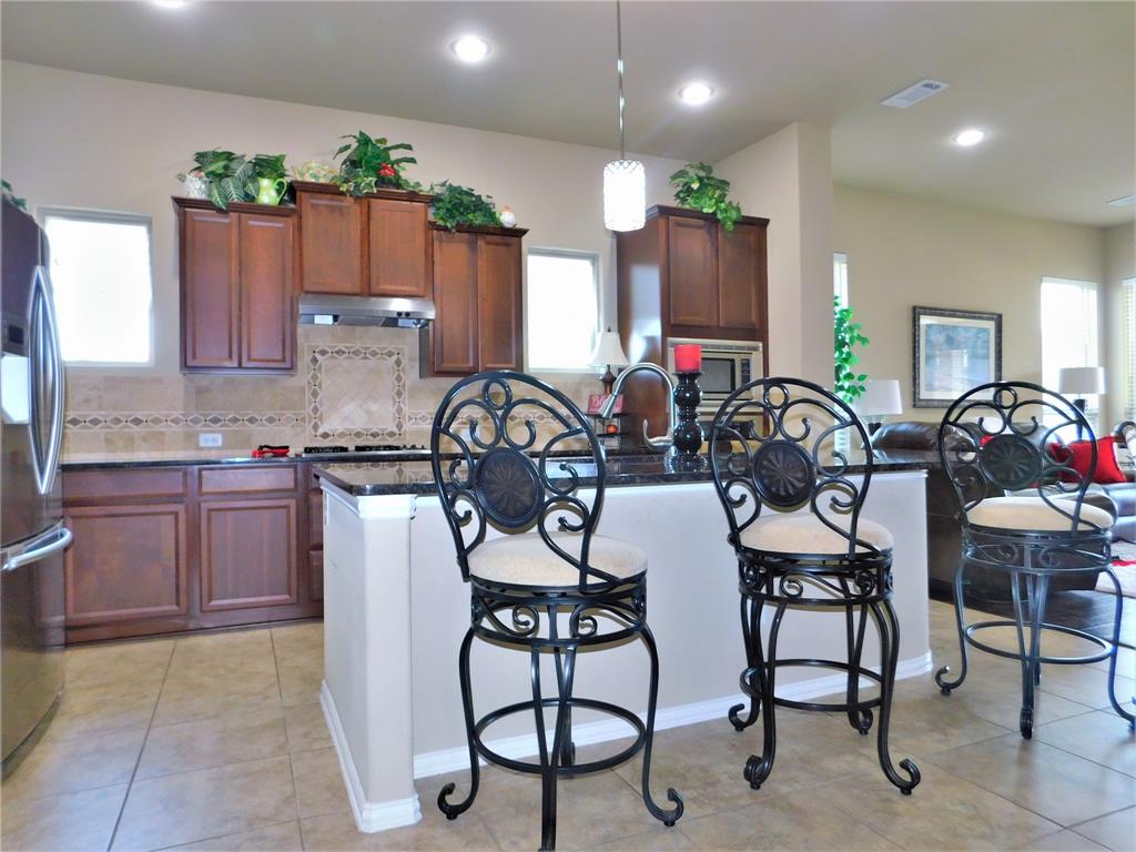 7712 Sweetgate Lane Denton, TX 76208 - Photo 8 of 40 a view of a dining room with furniture and chandelier