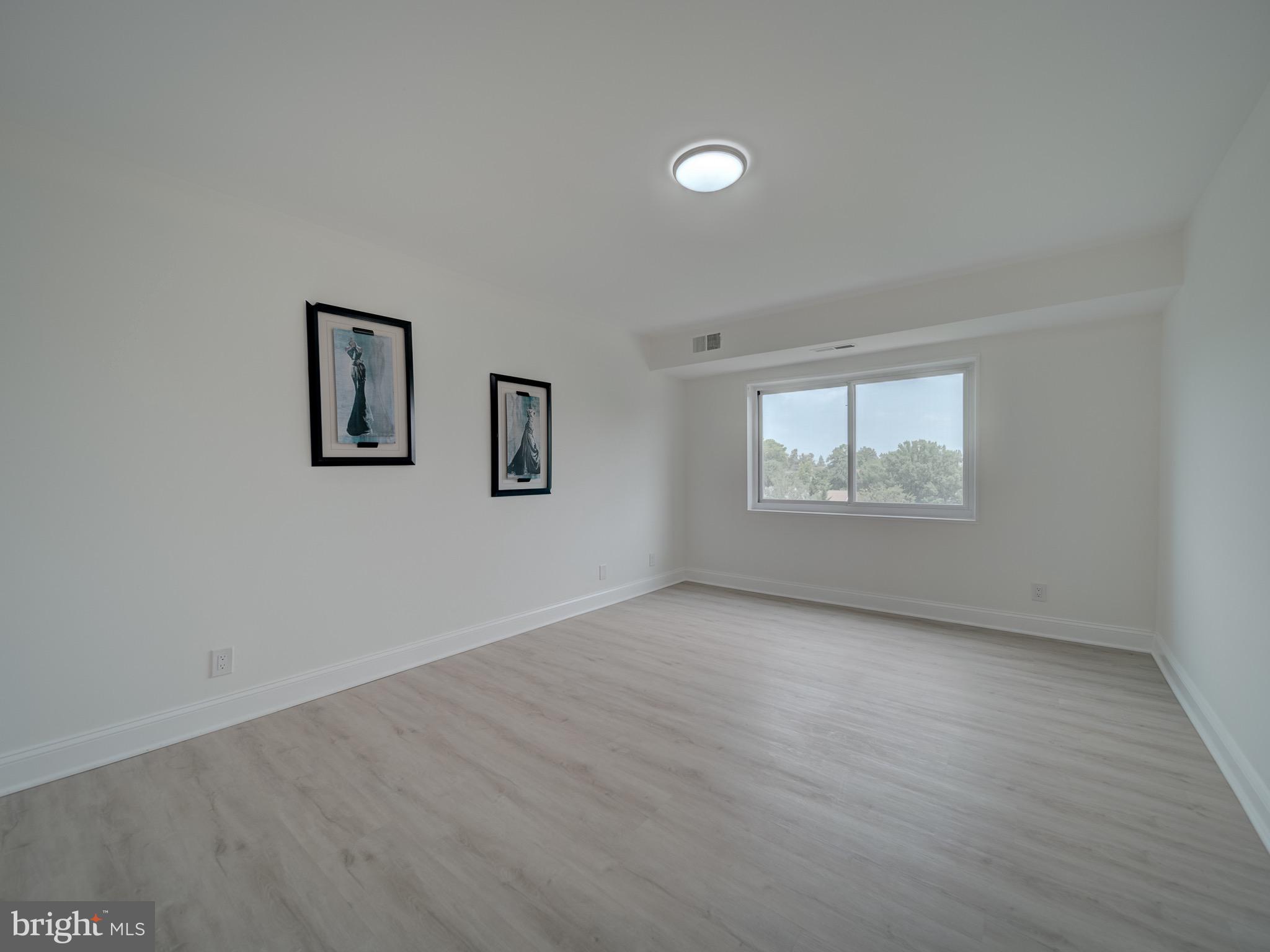 12001 Old Columbia Pike, Unit 514 Silver Spring, MD 20904 - Photo 7 of 41 an empty room with wooden floor and windows