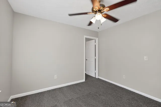 an empty room with a fan and a ceiling fan