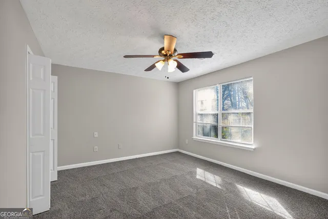 a view of a room with window and chandelier fan