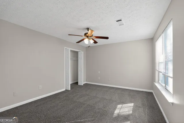 a view of a livingroom with a ceiling fan and window