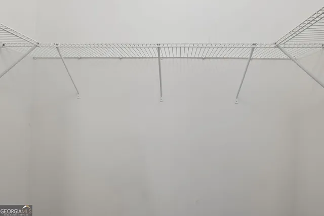 a view of a house with a small yard and wooden deck