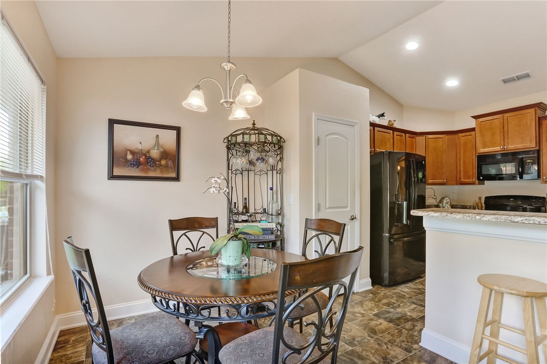 88156 Maybourne Road Yulee, FL 32097 - Photo 14 of 35 a view of a dining room with furniture a chandelier and wooden floor