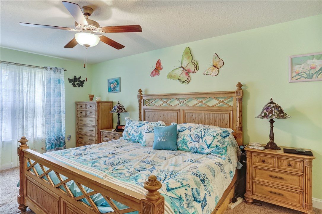 88156 Maybourne Road Yulee, FL 32097 - Photo 19 of 35 a bedroom with a bed and a chandelier