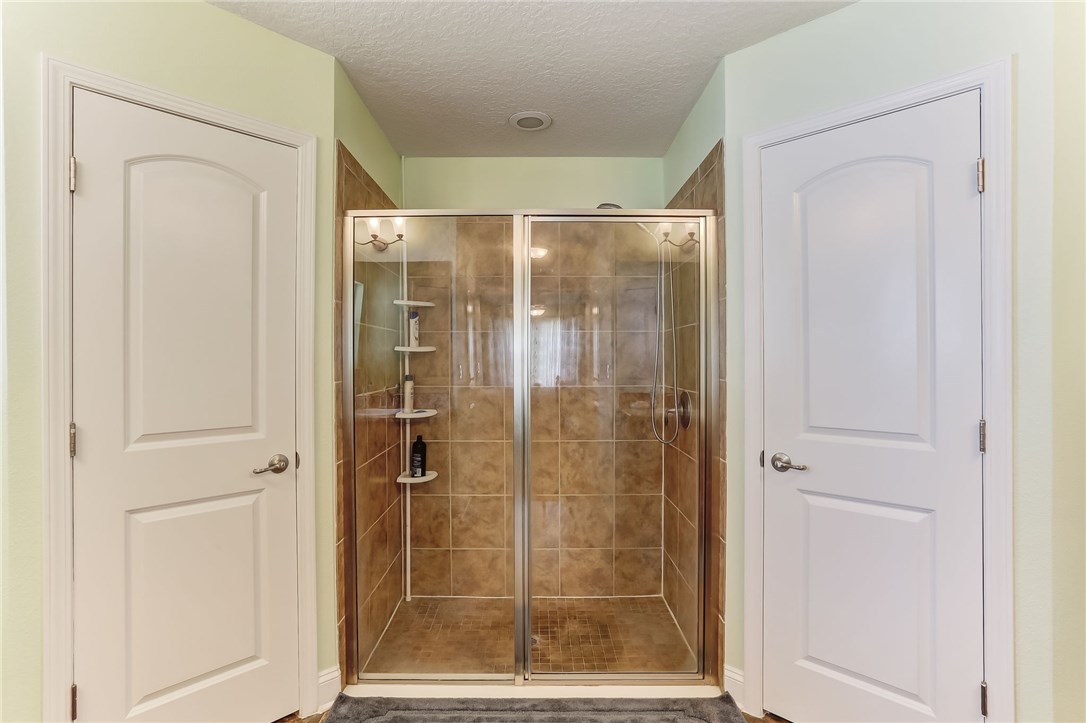 88156 Maybourne Road Yulee, FL 32097 - Photo 22 of 35 a bathroom with a glass shower door