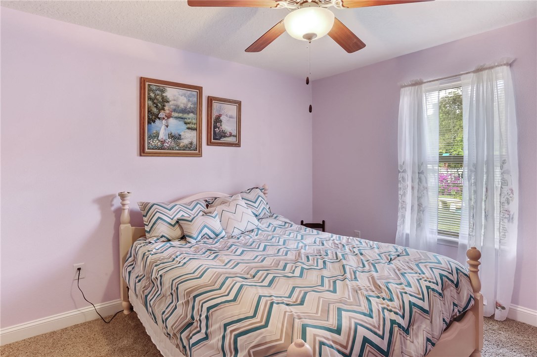 88156 Maybourne Road Yulee, FL 32097 - Photo 24 of 35 a bedroom with a large bed and a chandelier
