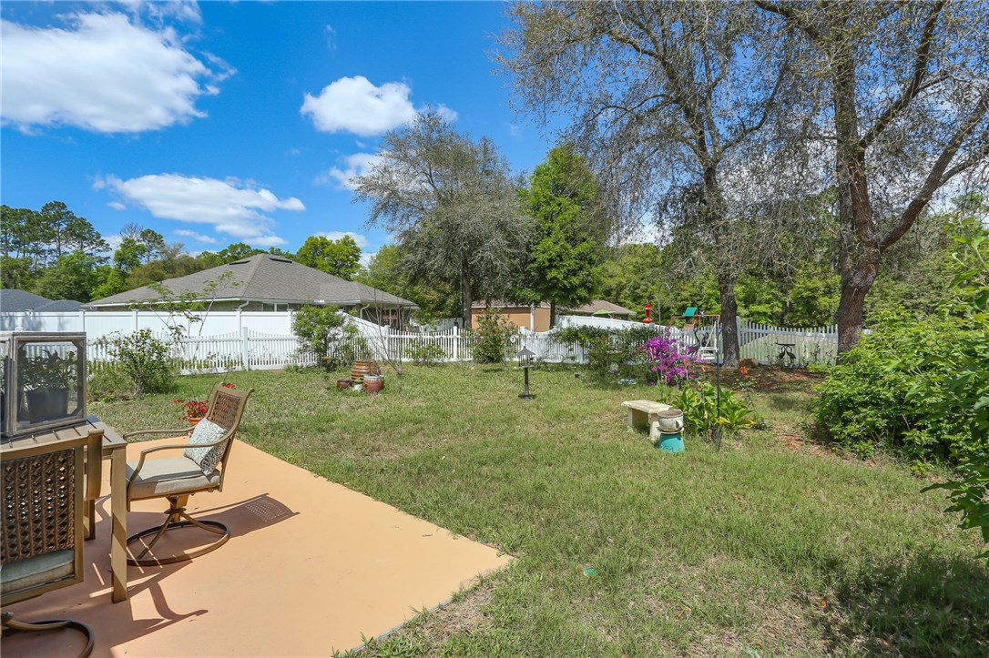 88156 Maybourne Road Yulee, FL 32097 - Photo 27 of 35 a view of a house with backyard sitting area and garden