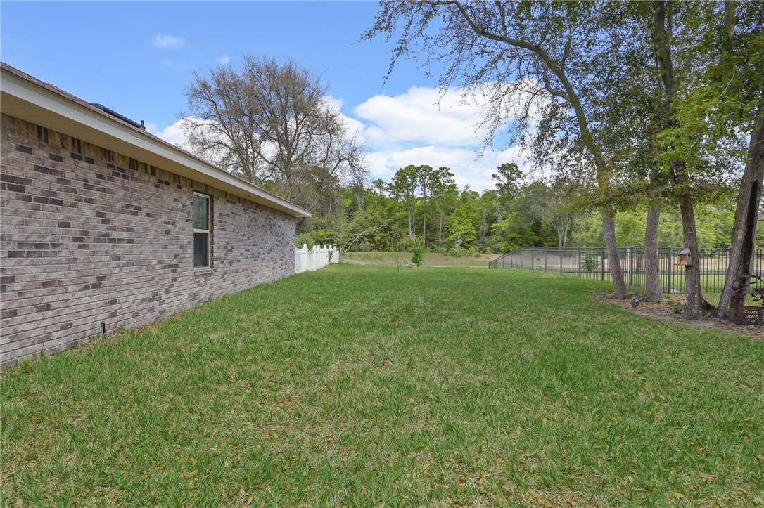 88156 Maybourne Road Yulee, FL 32097 - Photo 34 of 35 a backyard of a house with lots of green space