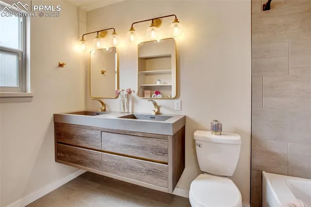 a bathroom with a sink a toilet and a mirror