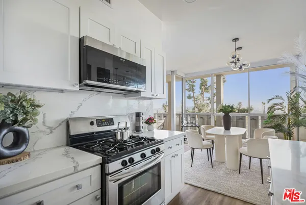 a kitchen with stove a sink and cabinets