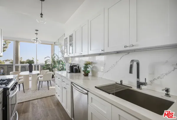 a kitchen with stainless steel appliances granite countertop a stove a sink and a refrigerator