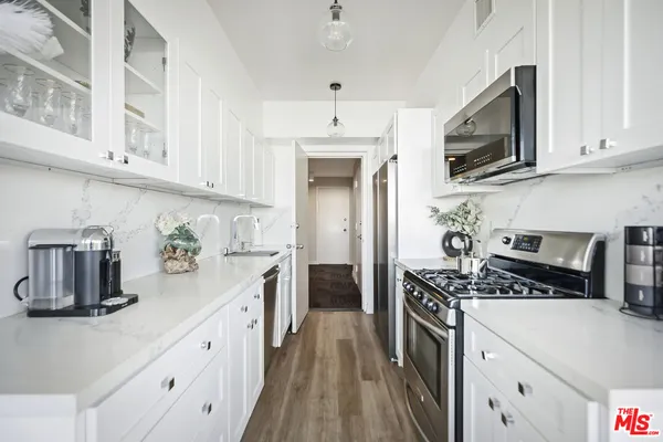 a dining room with furniture a potted plant and a floor to ceiling window