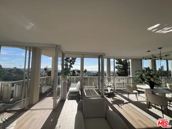 a living room with furniture potted plant and a large window