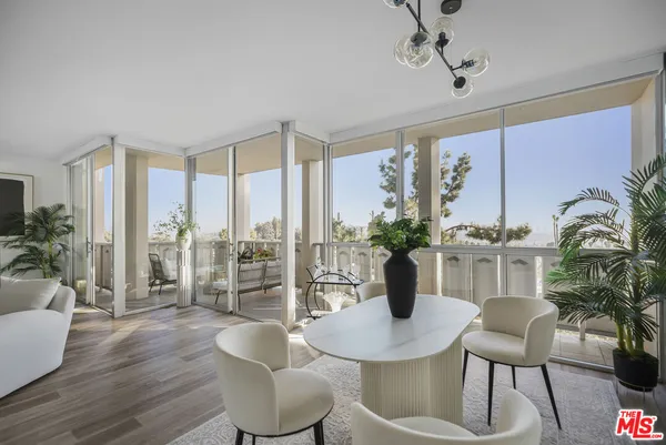a living room with furniture a flat screen tv and a floor to ceiling window