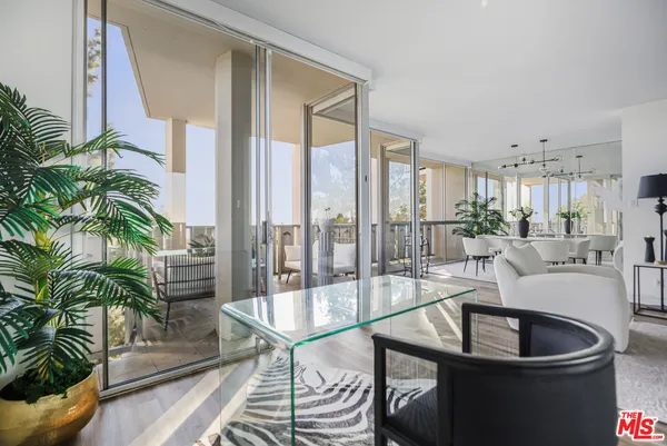 a living room with furniture and a glass door shower